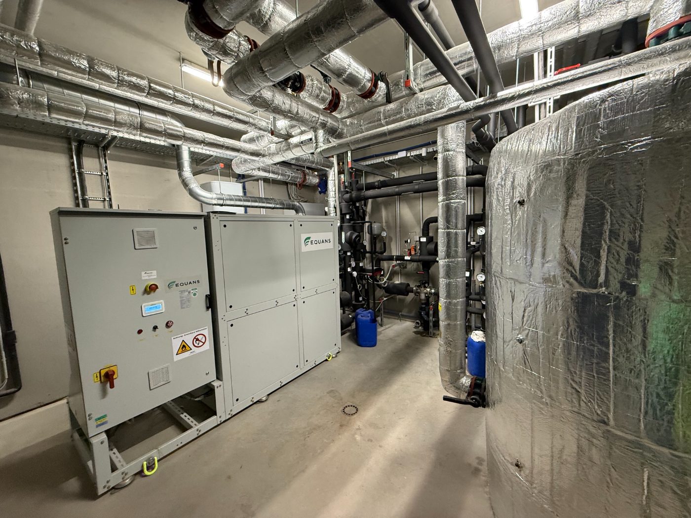 Technikraum einer Grundwasser-Wärmepumpenanlage mit Verteiler und Speicher